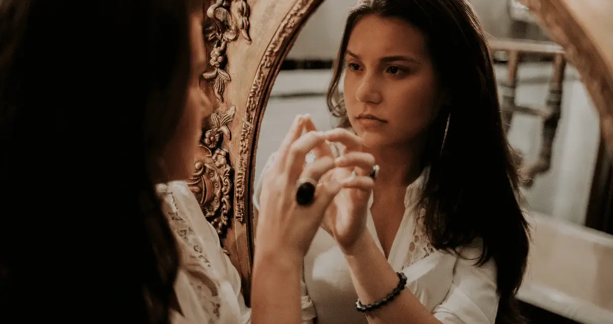 Vrouw-kijkt-bedroeft-in-een-spiegel-naar-zichzelf