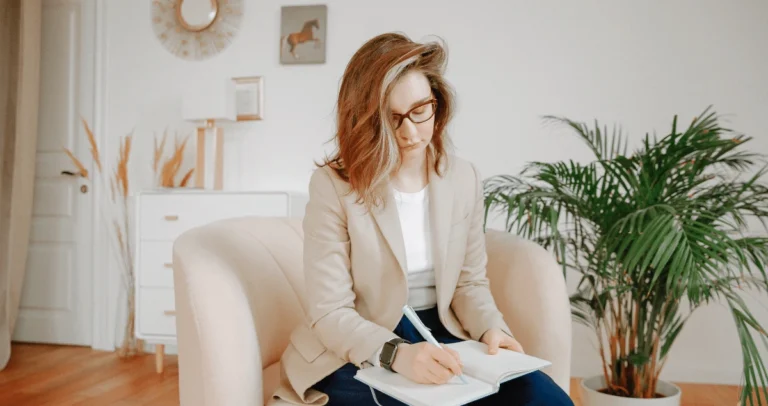 Vrouwelijke-therapeut-zit-op-een-stoel-aantekeningen-te-maken